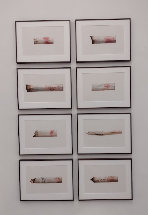Eight landscape photos of lipstick marked cigarettes on a white wall